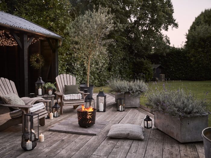 Garden at dusk with fire pit and lanterns on decking