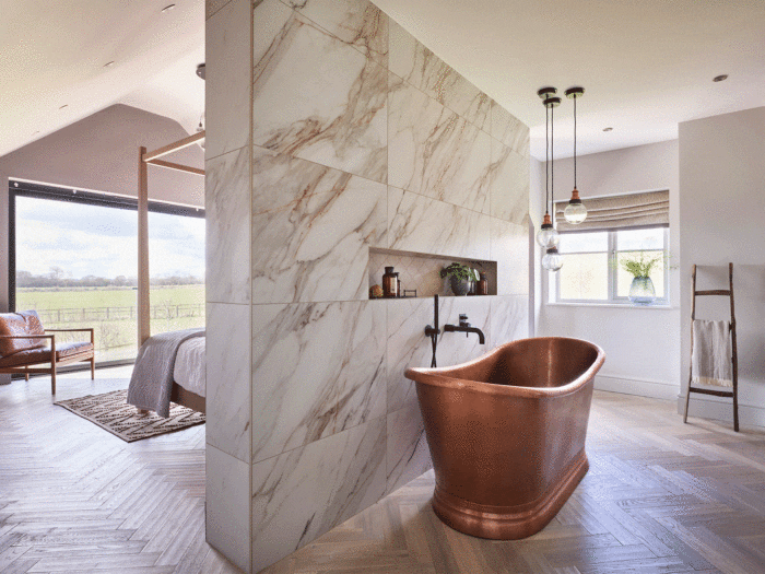 A copper bathtub behind a partition wall can help divide the space