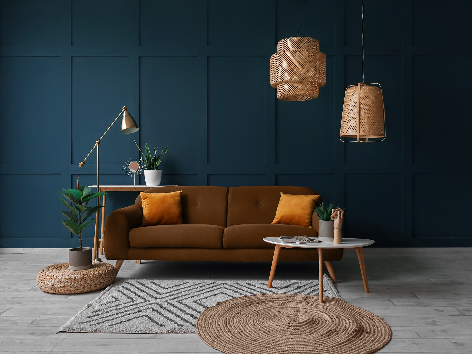 Interior of living room with brown sofa, tables and wicker ceiling lamps