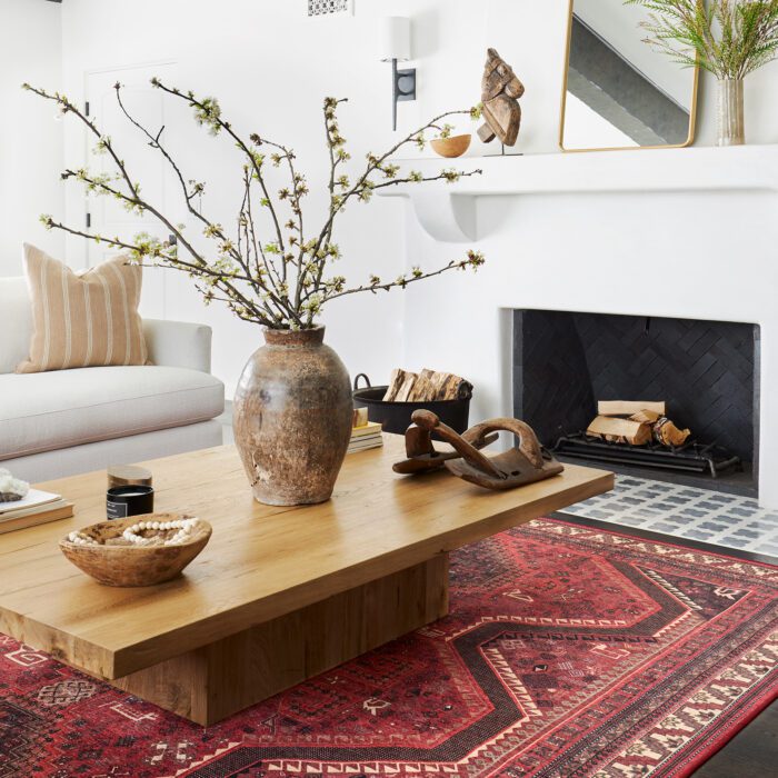 A living room with a red patterned rug