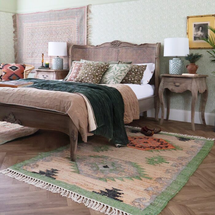 A bedroom with a rug on the wall and another under the bed