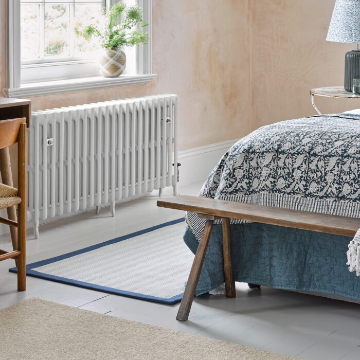 A bedroom with two rugs on the floor