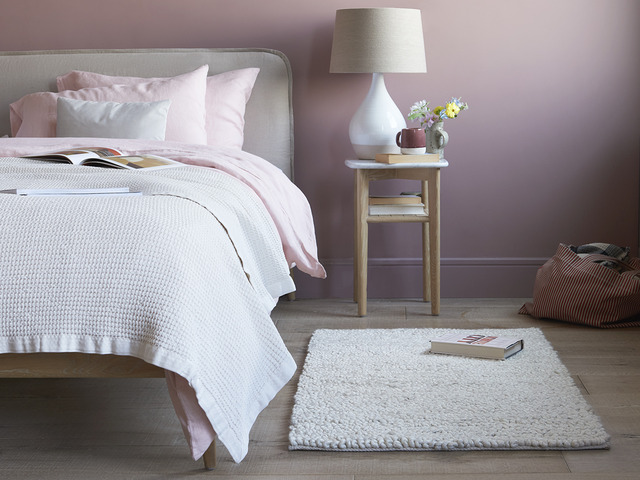 Cosy bedroom layout with rug on hardwood floor