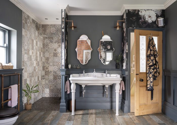 SIDE BY SIDE Building out a wall for a walk-in shower also meant creating an alcove which was the ideal spot for the vanity unit, with double sinks to beat the morning rush and matching wall lights and mirrors. 